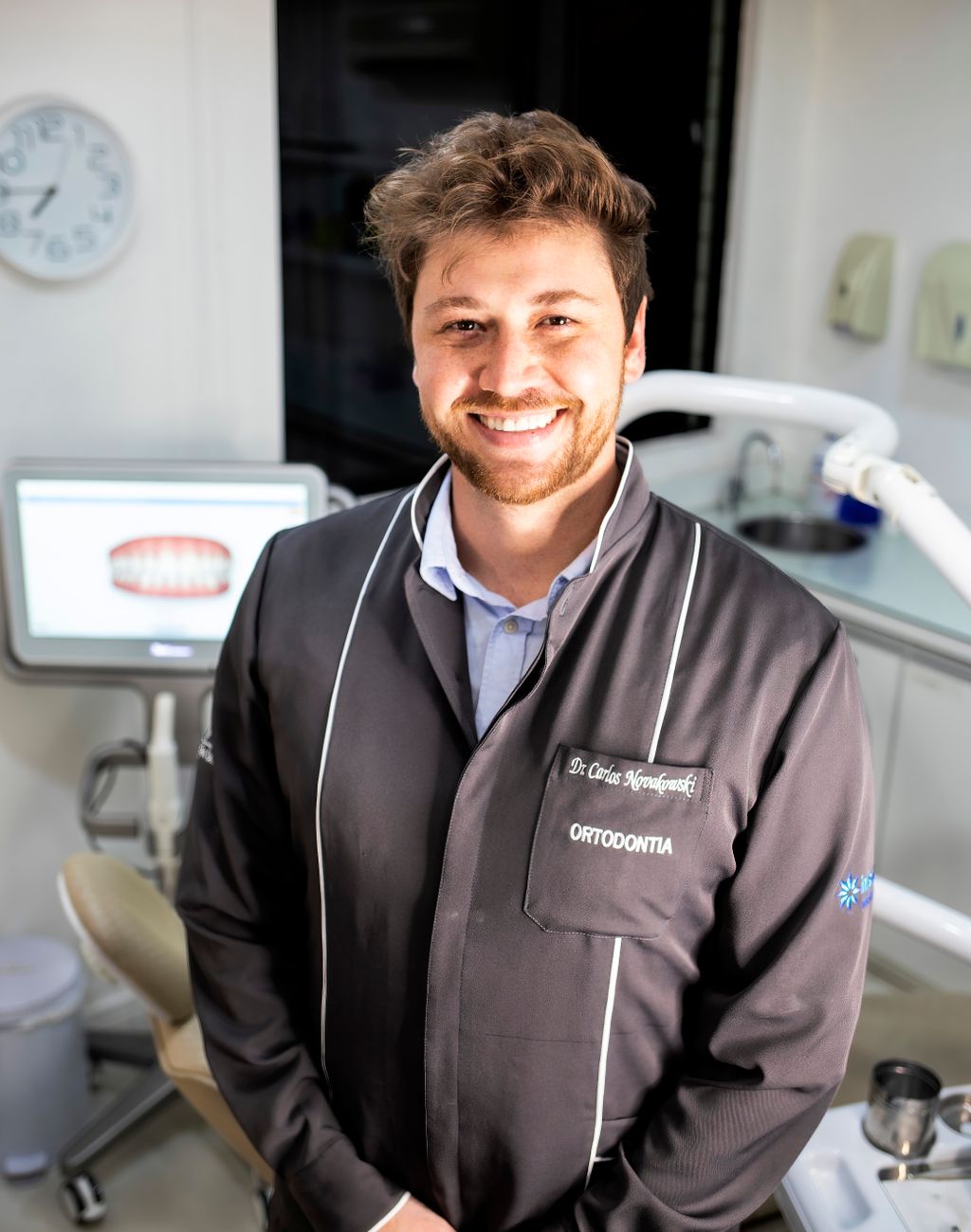 Dentista sorridente in uno studio odontoiatrico moderno pronto ad accogliere i pazienti